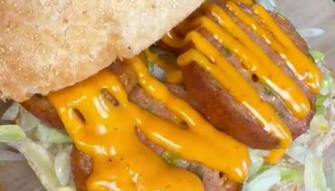 Krokant broodje met kipgrillworst, ijsbergsla en cheddarsaus