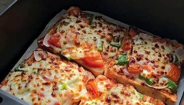 Vier goudbruin gebakken broodpizza’s met mozzarella, paprika, tomaat en rode ui in een Airfryer