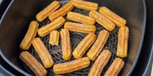 Goudbruine churros met kaneelsuiker in een open Airfryermand