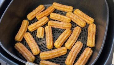 Goudbruine churros met kaneelsuiker in een open Airfryermand