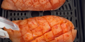 Kruislings ingesneden en gekruide kipfilets in het mandje van de Airfryer