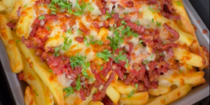 Loaded fries met krokante spekjes, gesmolten kaas en peterselie in een Airfryer-bakvorm