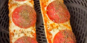 Twee pizza broodjes met salami, gesmolten kaas en Italiaanse kruiden in de Airfryer