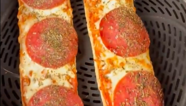 Twee pizza broodjes met salami, gesmolten kaas en Italiaanse kruiden in de Airfryer