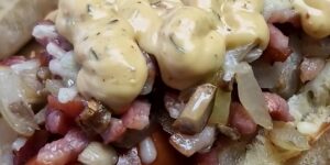 Broodje rookworst met spekjes, ui, champignons, gesmolten kaas en Unox-saus